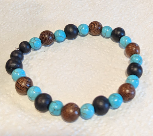 Beaded bracelet with blue, black, and brown beads on a textured white background $20