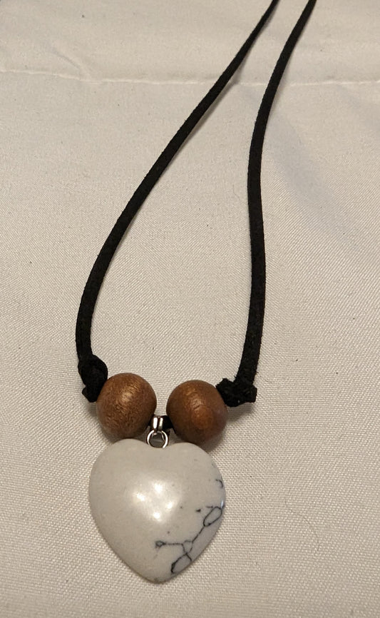 White pendant necklace with wooden beads on a black leather adjustable cord.