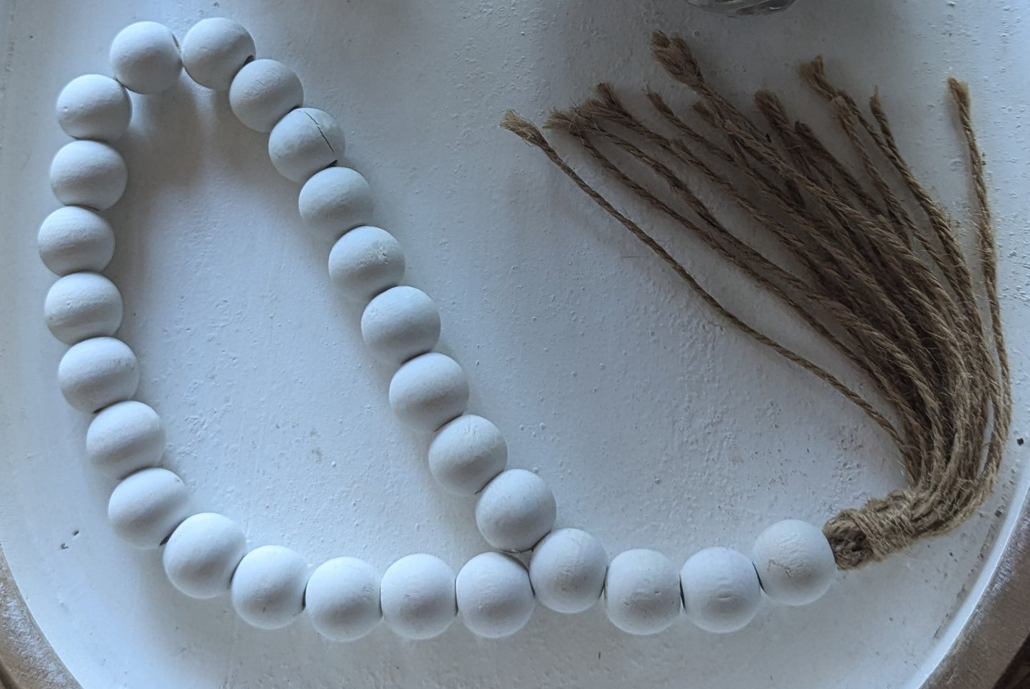 Small white beaded cord decoration with a tassel