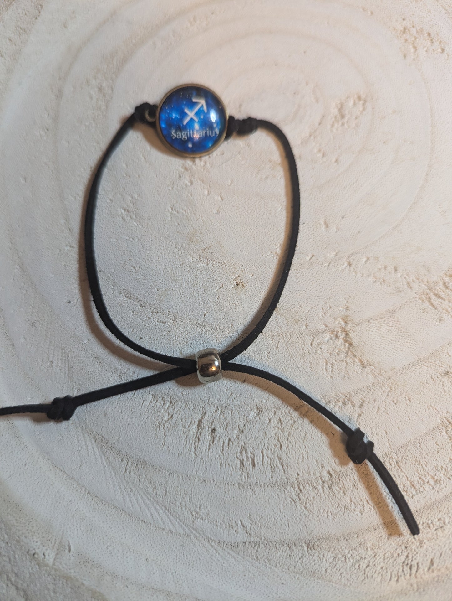 Black cord bracelet with a blue glass bead