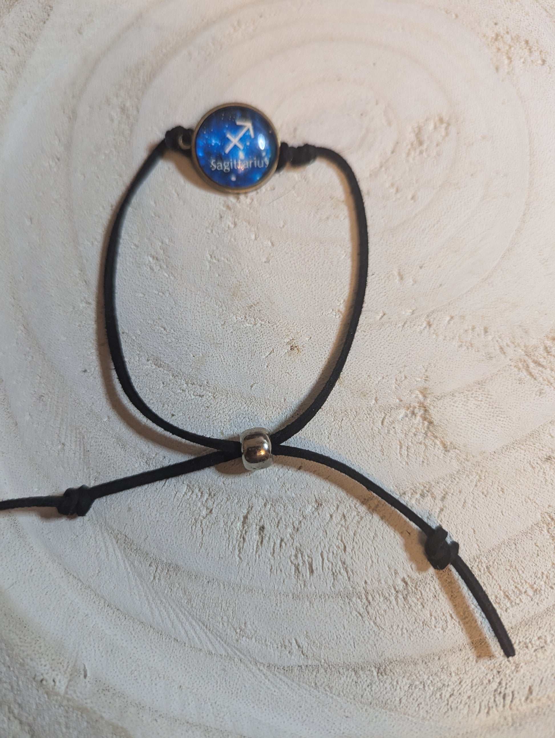 Black cord bracelet with a blue glass bead
