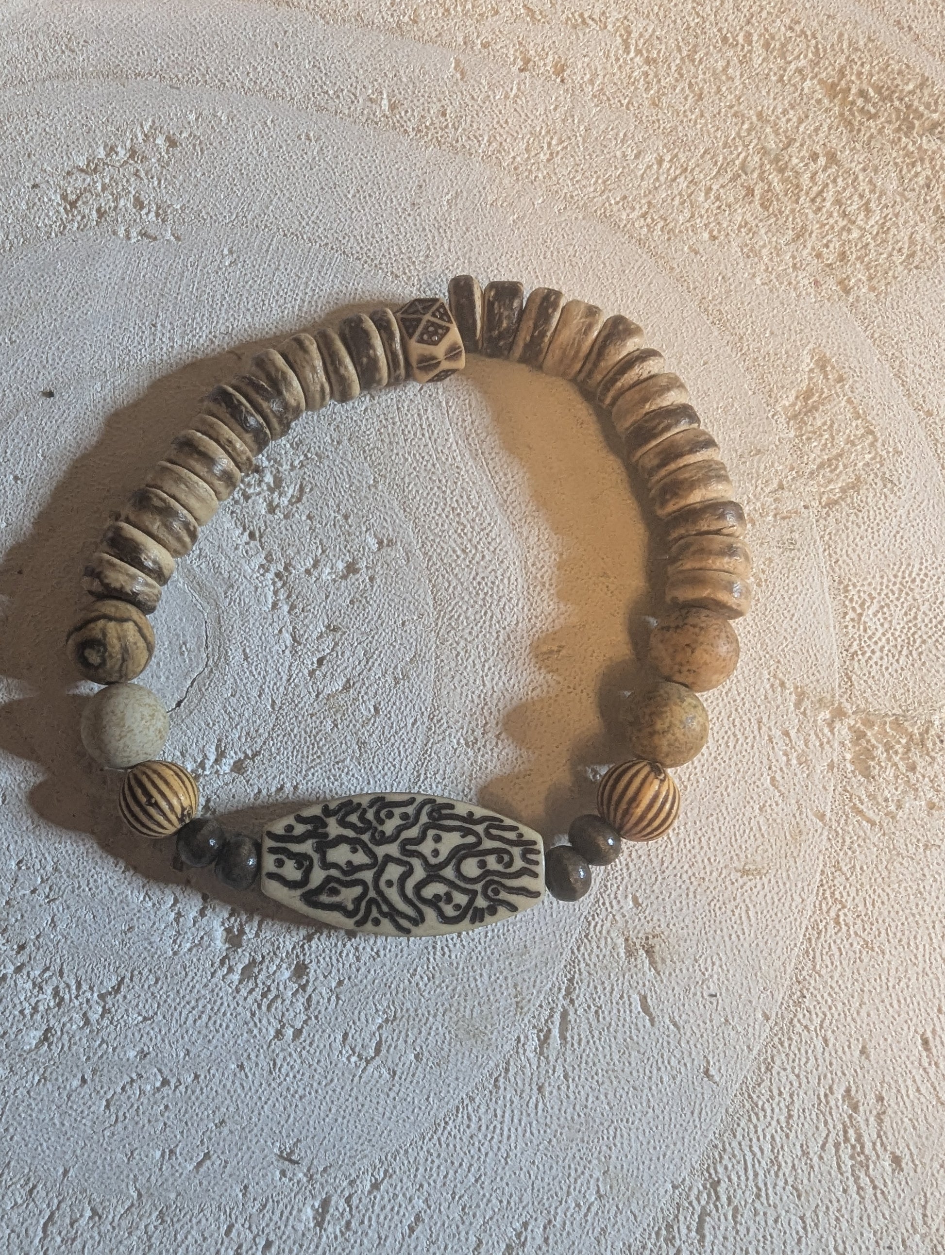 Coconut bracelet with textured wooden beads and pendant.