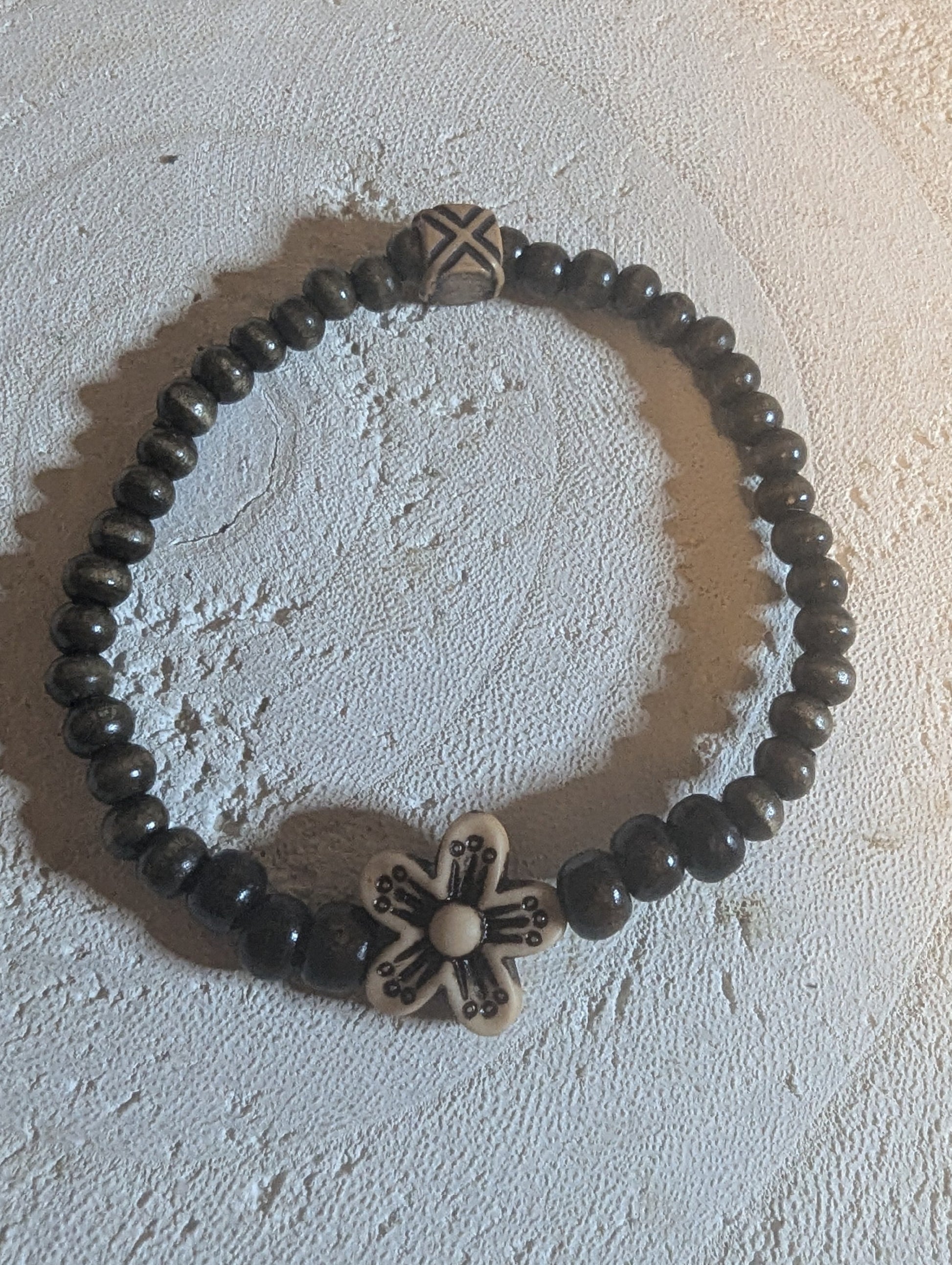 Bracelet with brown  wooden beads and decorative floral elements 