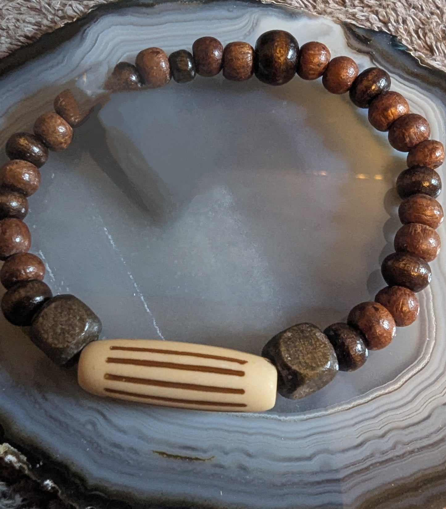 Wooden beaded bracelet with a bar-shaped charm 