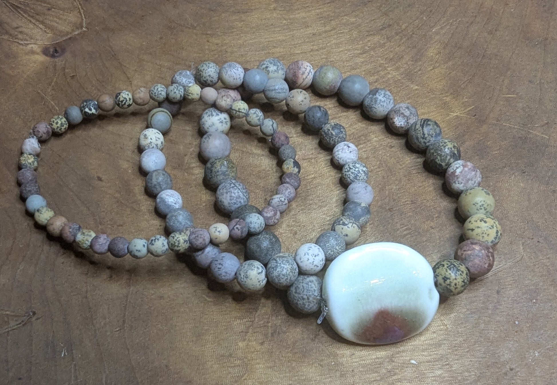 Necklace with round beads and a large white stone