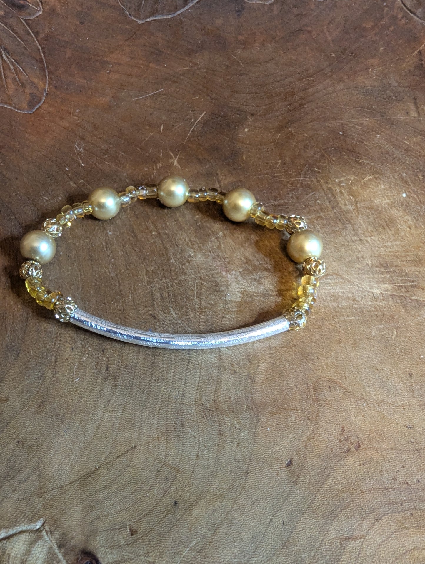 Bracelet with pearls  and gold toned beads on a silver bar 