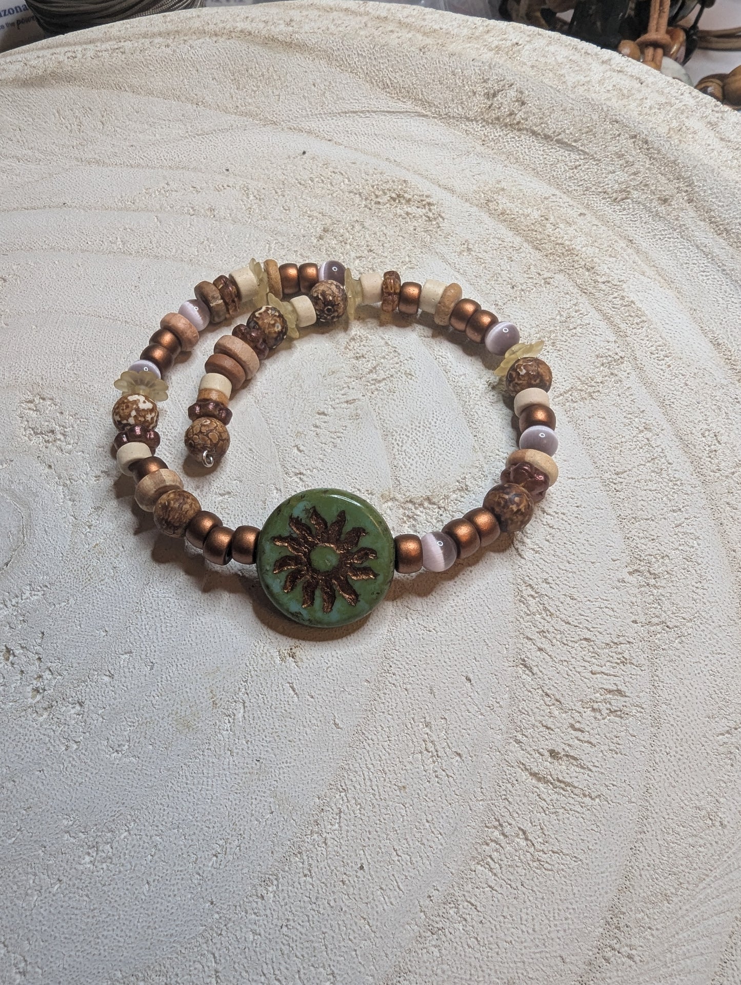 Beaded bracelet with a green central sun pendant