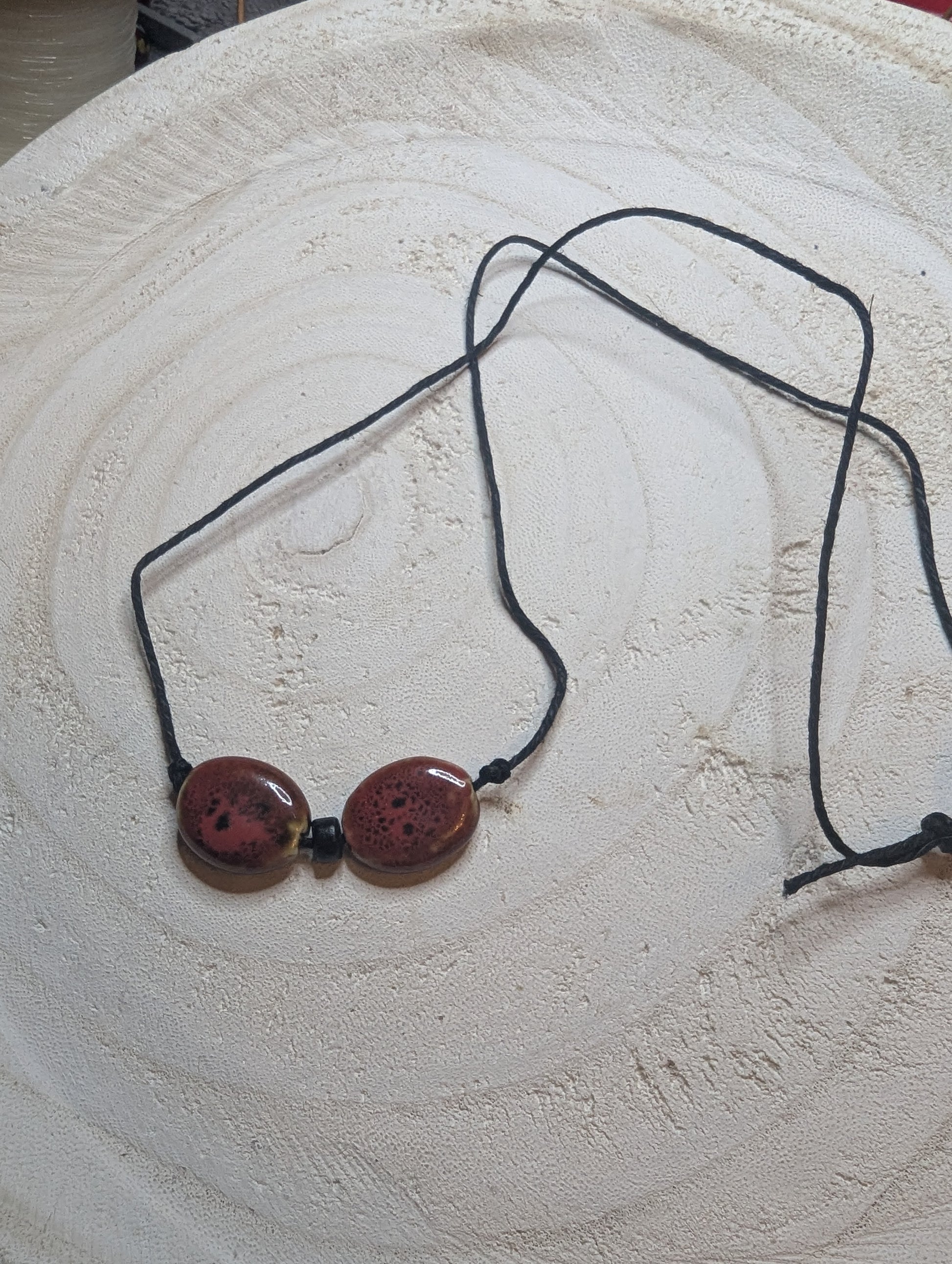 Necklace with two round brownish red beads directly from Sedona Arizona on a black cord