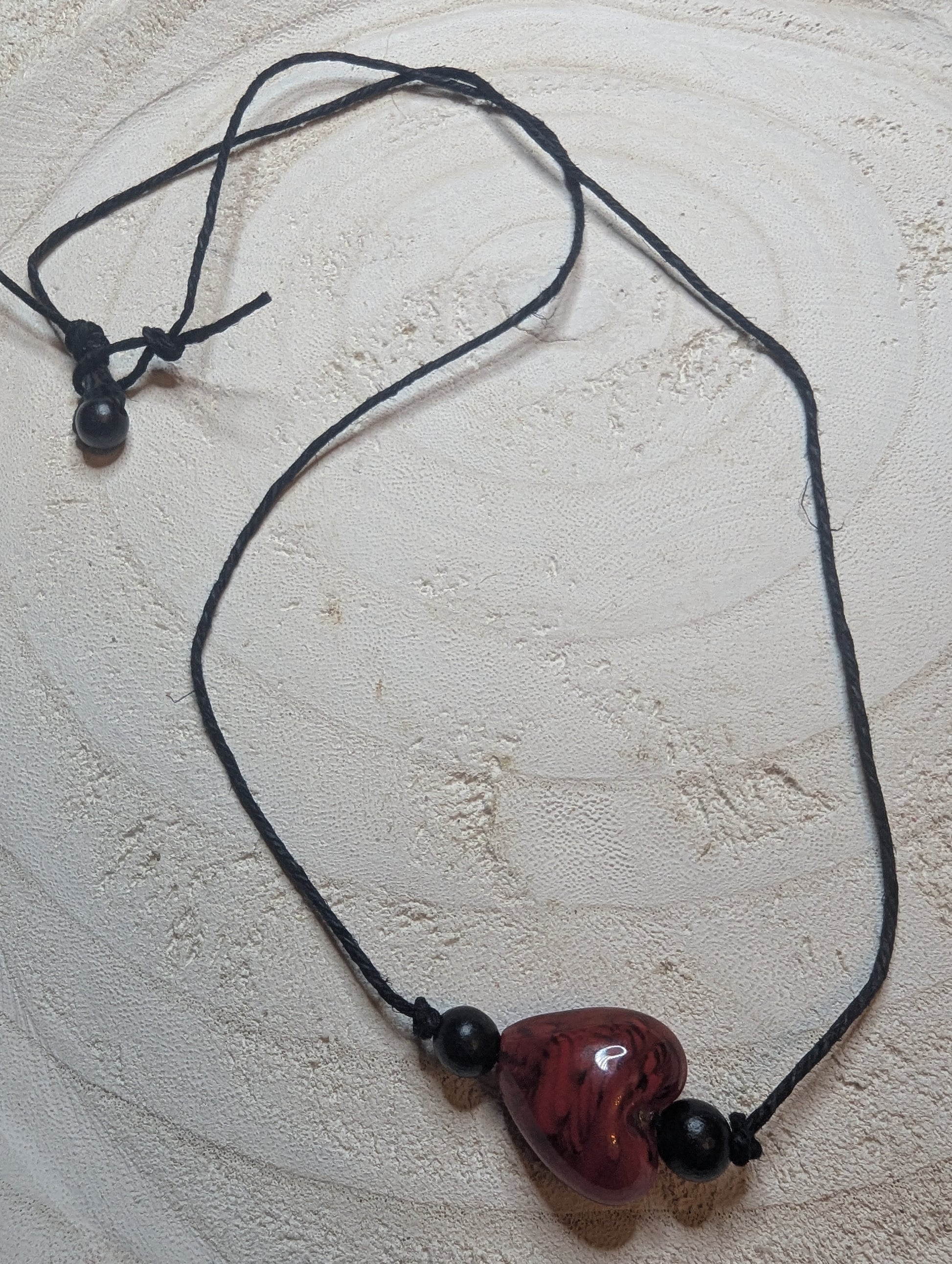 Necklace with a red heart-shaped pendant and black beads $20