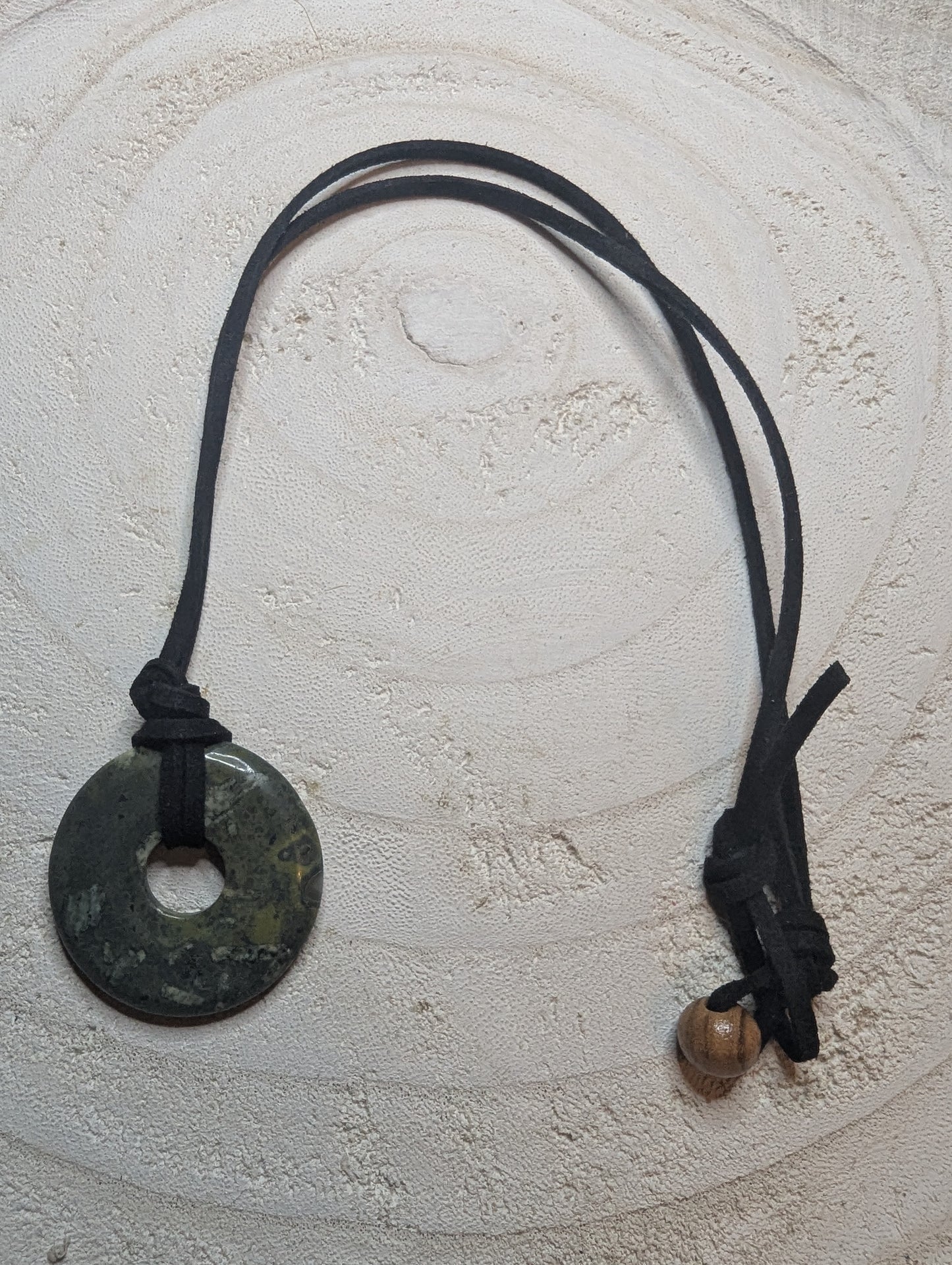 Necklace with a round pendant and leather cord