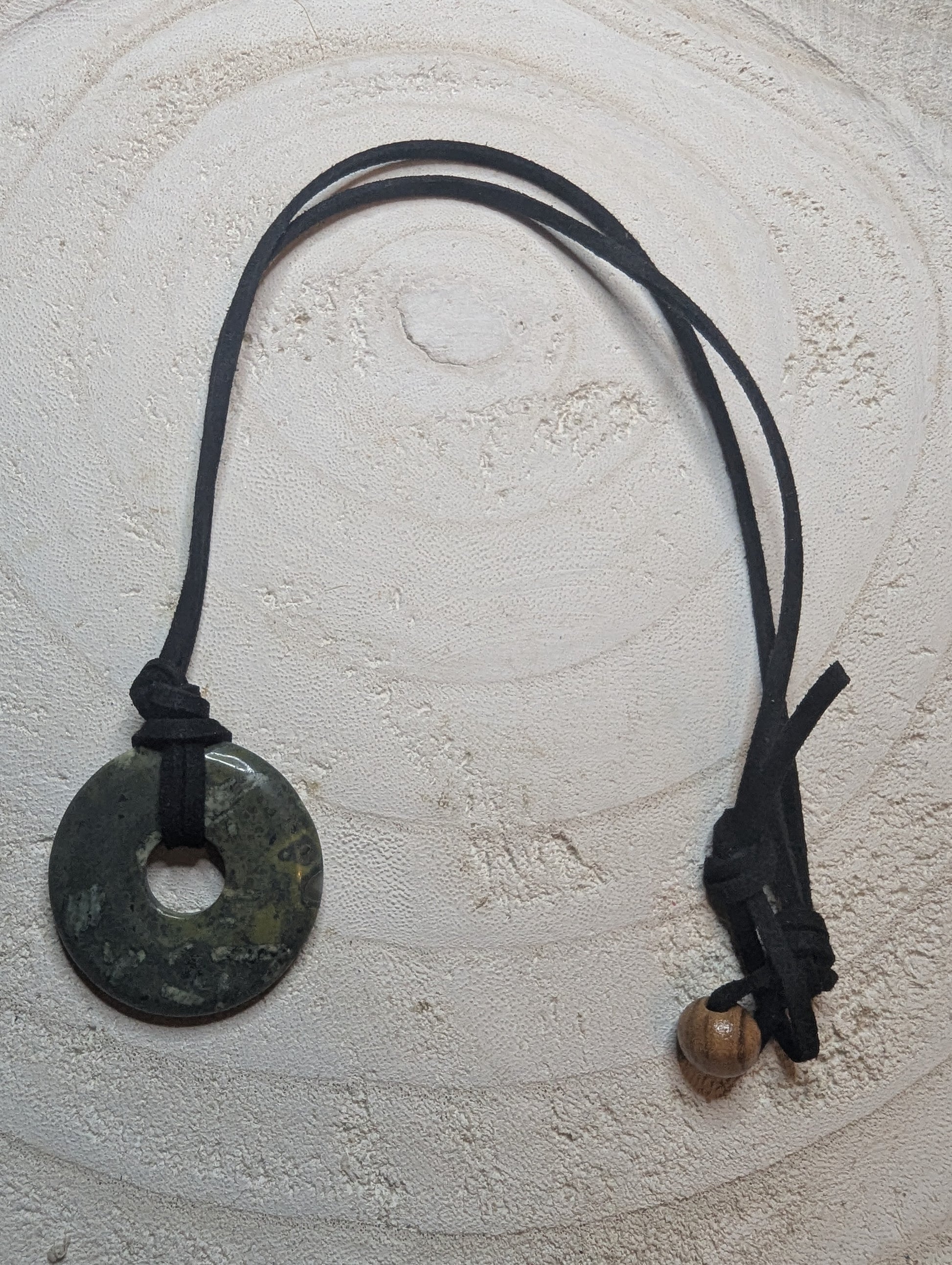 Necklace with a round pendant and leather cord