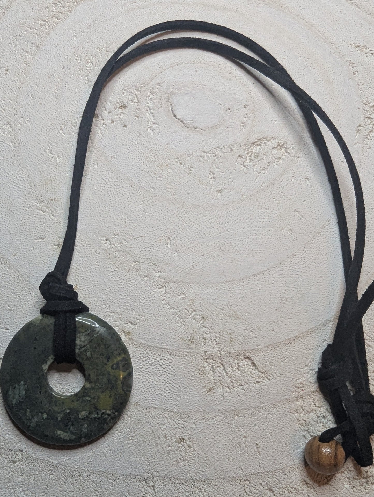 Necklace with a round pendant and leather cord $20