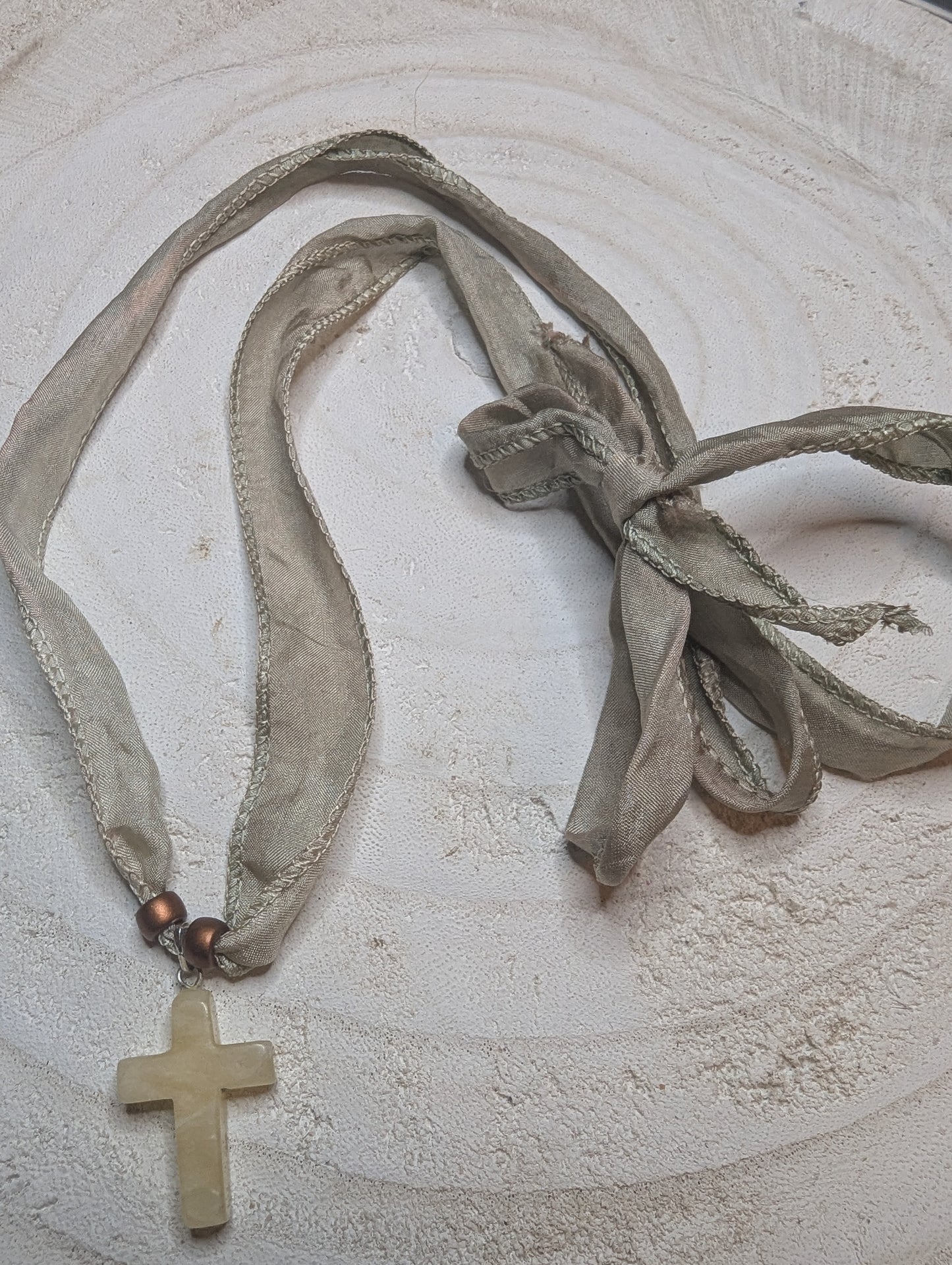 Necklace with a cross pendant and ribbons