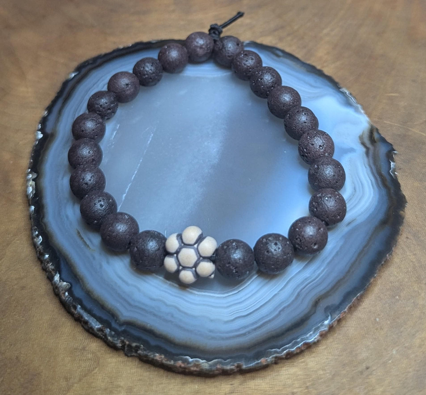 Black lava beaded stretch bracelet with flower pendant
