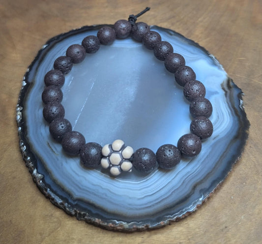 Black lava beaded stretch bracelet with flower pendant